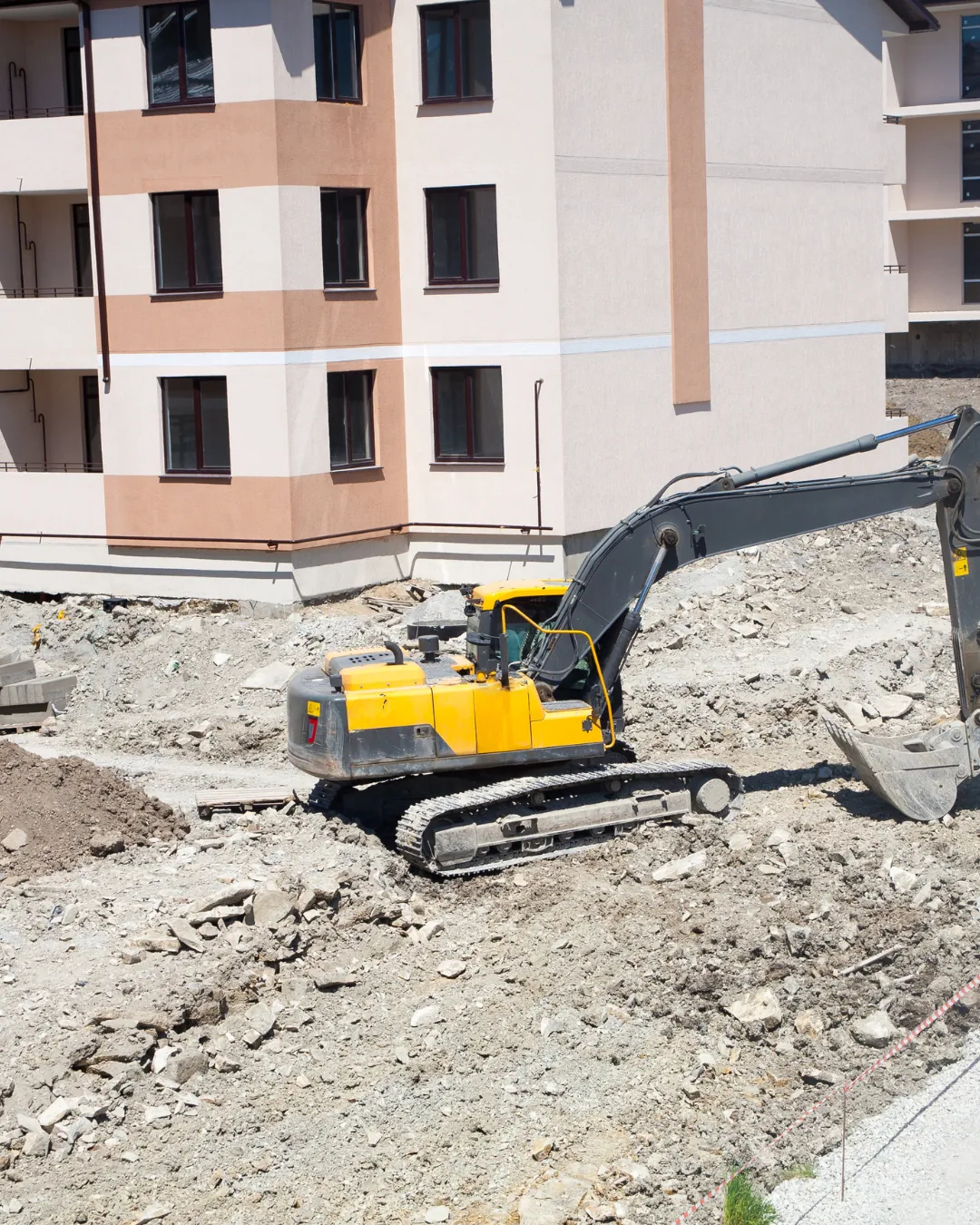 Excavator beside a multi-story building