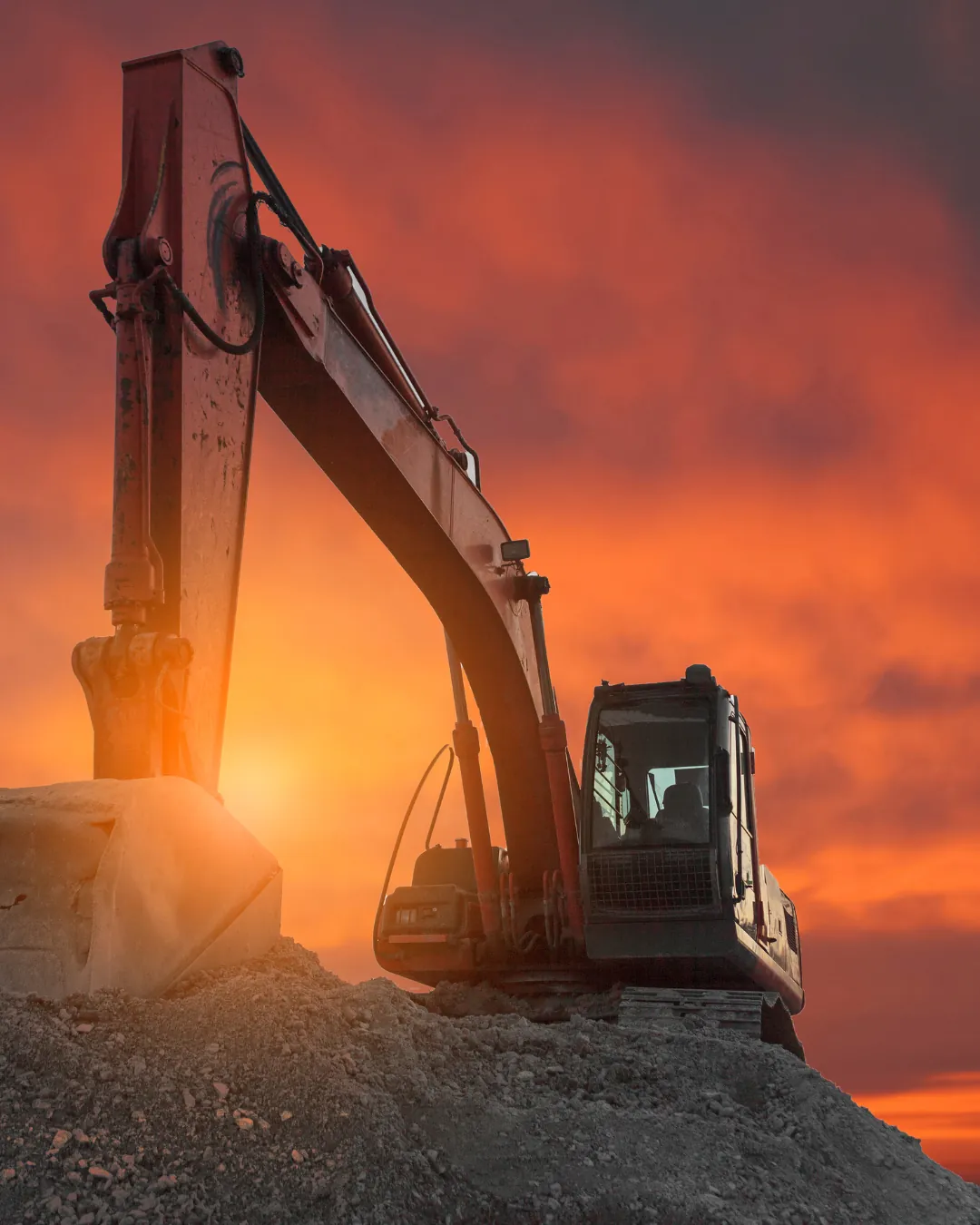 Excavator silhouetted at sunset